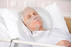 Senior man ill in hospital bed photo