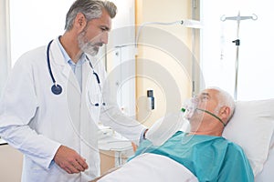 Senior man inhaling through oxygen mask in clinic