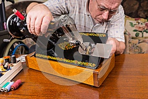 Senior Man Inspecting Old Fashioned Sewing Machine