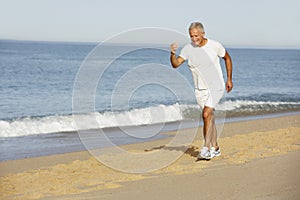 Senior Man Jogging Along Beach