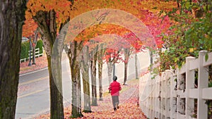 Senior man jogging along sidewalk in beautiful autumn foliage