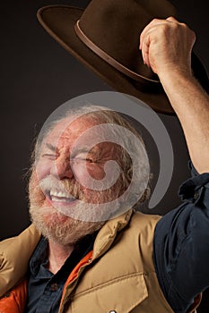 Hombre alegremente ondas un sombrero en el aire 