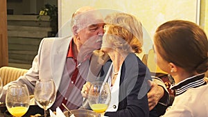 Senior man kissing his woman in indoor cafe