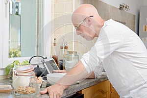 Senior man in kitchen using tablet