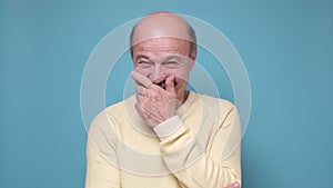 Senior man laughing and embarrassed giggle covering mouth with hands