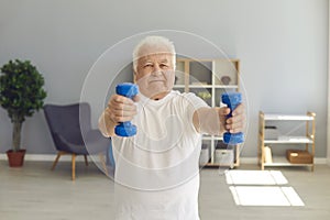 Senior man leading active lifestyle exercising with dumbbells in his living-room