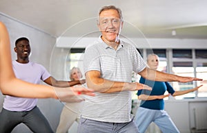 Senior man learning to dance krump with group of older people