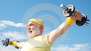 Senior man lifting dumbbell. Portrait of healthy happy smile senior. Senior sportsman in sport center. Senior man in his