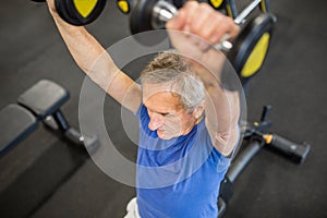 Senior man lifting weights on hammer strength machine