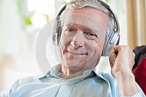 Senior Man Listening To Music On Wireless Headphones