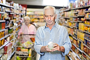 Senior man looking at canned food