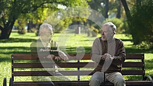 Senior man looking at empty bench and remembering his friend, loss, memories