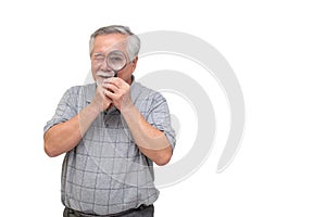 Senior man looking through magnifying glass and smiling isolated on white background