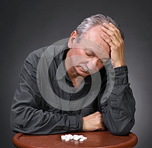 Senior man looking at pills