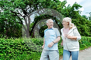 Senior man looking at wife while running in park