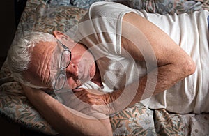 Old man lying in bed