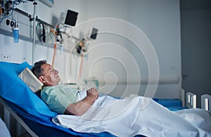 Senior man lying in a hospital bed.