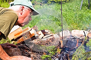 Senior man making bonfire