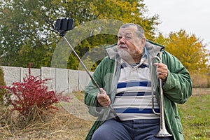 Senior man making faces while doing selfie outdoor