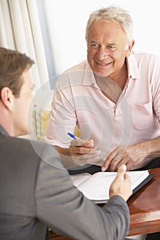 Senior Man Meeting With Financial Advisor At Home