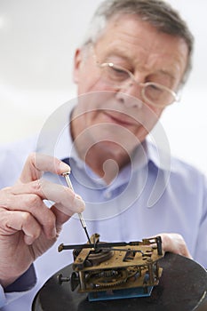 Senior Man Mending Clock Mechanism