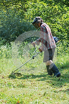 Senior man mowing green grass