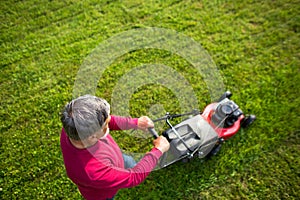 Senior man mowing his garden