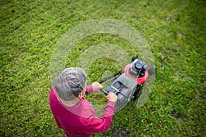 Senior man mowing his garden - shot from above