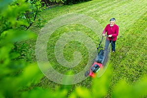 Senior man mowing his garden - shot from above