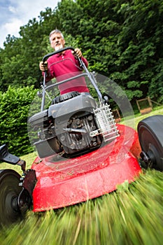 Senior man mowing the lawn