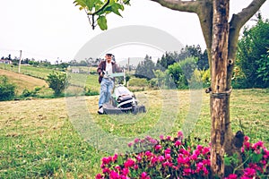 Senior man mowing the lawn with lawnmower