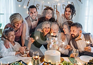 A senior man with multigeneration family celebrating birthday on indoor party.