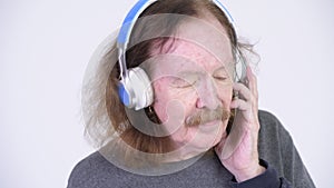 Senior man with mustache listening to music