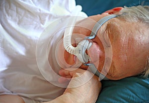 Man with sleep apnea uses breathing device photo