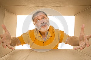 Senior man opening the biggest postal package isolated on white