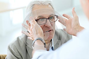 Senior man in optical store trying on eyeglasses