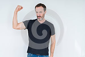 Senior man over isolated background Strong person showing arm muscle, confident and proud of power