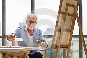 Senior man painting on canvas at home, Elderly man painting on a canvas, Happy retirement concepts