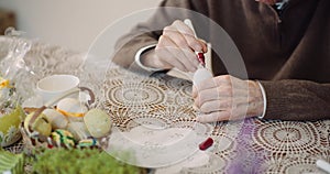 Senior man painting easter egg