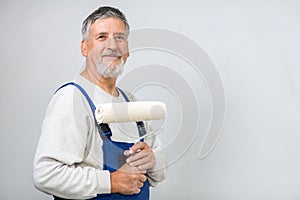 Senior man painting a wall in his home