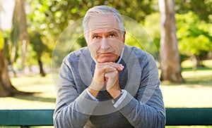 Senior, man or park with hands for thinking on retirement, contemplating or planning for holiday. Male person or elderly