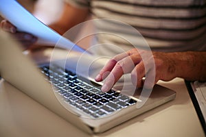 Senior man paying bills online on laptop.