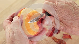 Senior man peeling a juicy peach