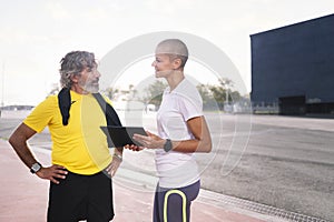 senior man and personal trainer planning training