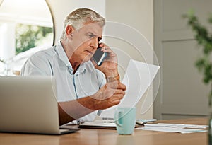 Senior man on a phone call with finance documents for debt counselling. Old male at home with his laptop and paperwork