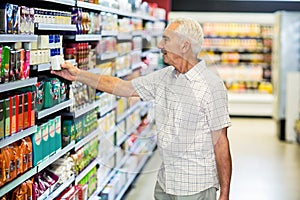 Senior man picking canned food