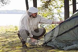 Senior man pitches a tent