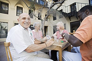 Senior Man Playing Cards With Friends