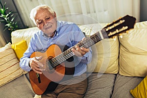 Senior man playing guitar at home