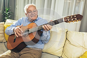 Senior man playing guitar at home